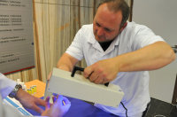 Hygienefachkraft Michael Bosmanns überprüft desinfizierte Hände mithilfe der UV-Lampe.